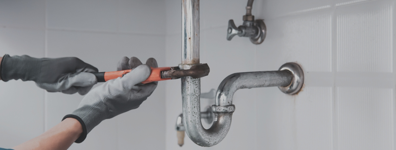 Barlow Plumbing Western NC Plumber fixing metal pipes with wrench